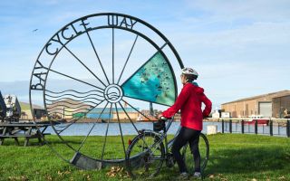 Cyclist at Glasson Dock Bay Cycle Way marker