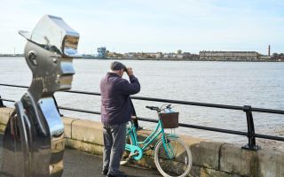 Knott End Lowry sculpture and man with bike and binoculars Wildey Media